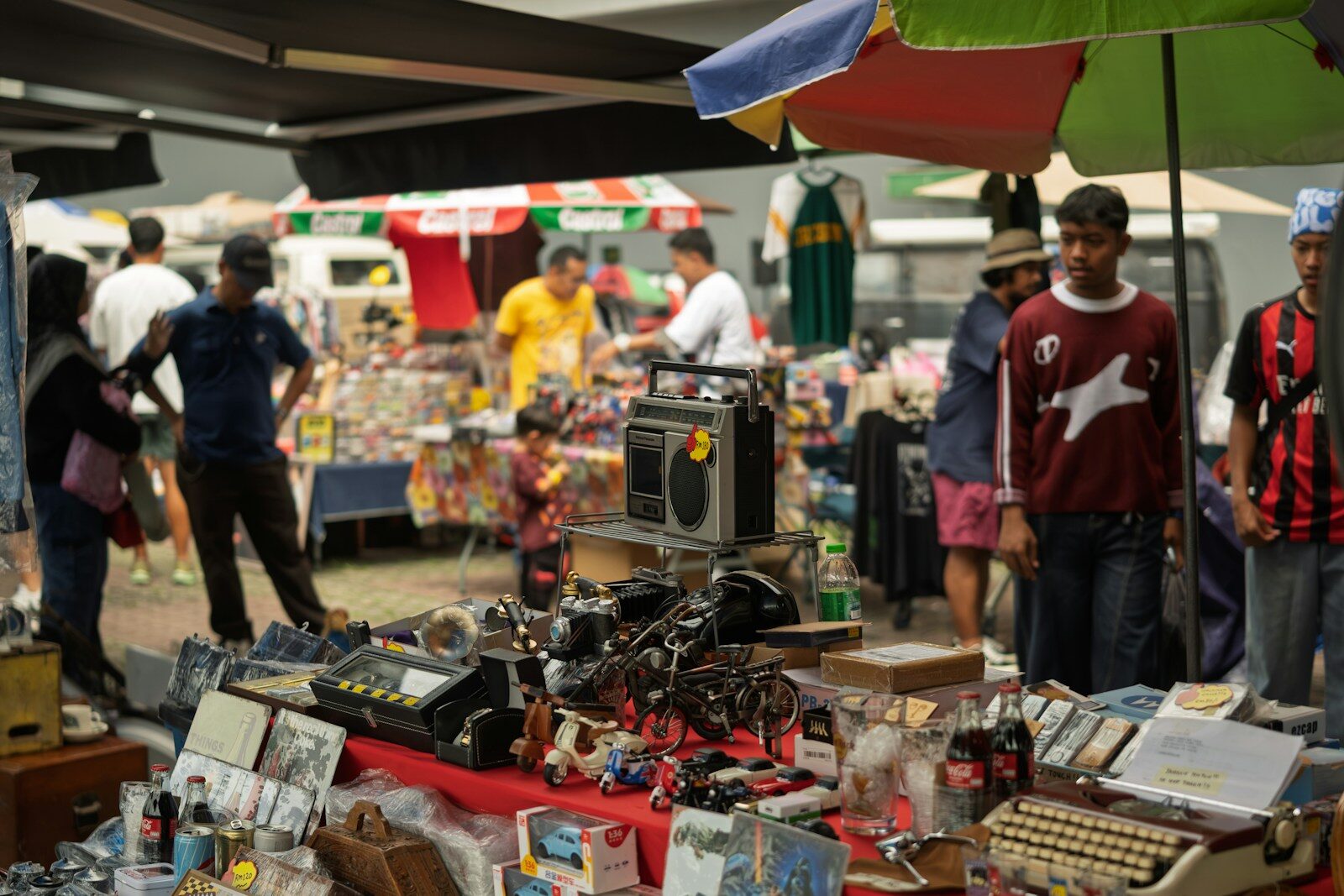 People browsing items at an outdoor market stall.